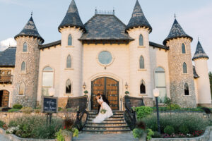 Bride and groom kissing on staircase in front of castle at Wadley Farms in Lindon Utah