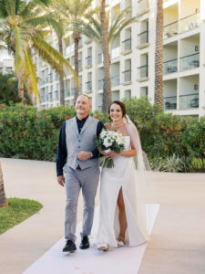 Bride walking down the aisle during a beachfront wedding ceremony at Hyatt Ziva Los Cabos in Cabo San Lucas, Mexico