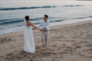 Bride and groom spinning on the beach at sunset during their destination wedding in Cabo Mexico.