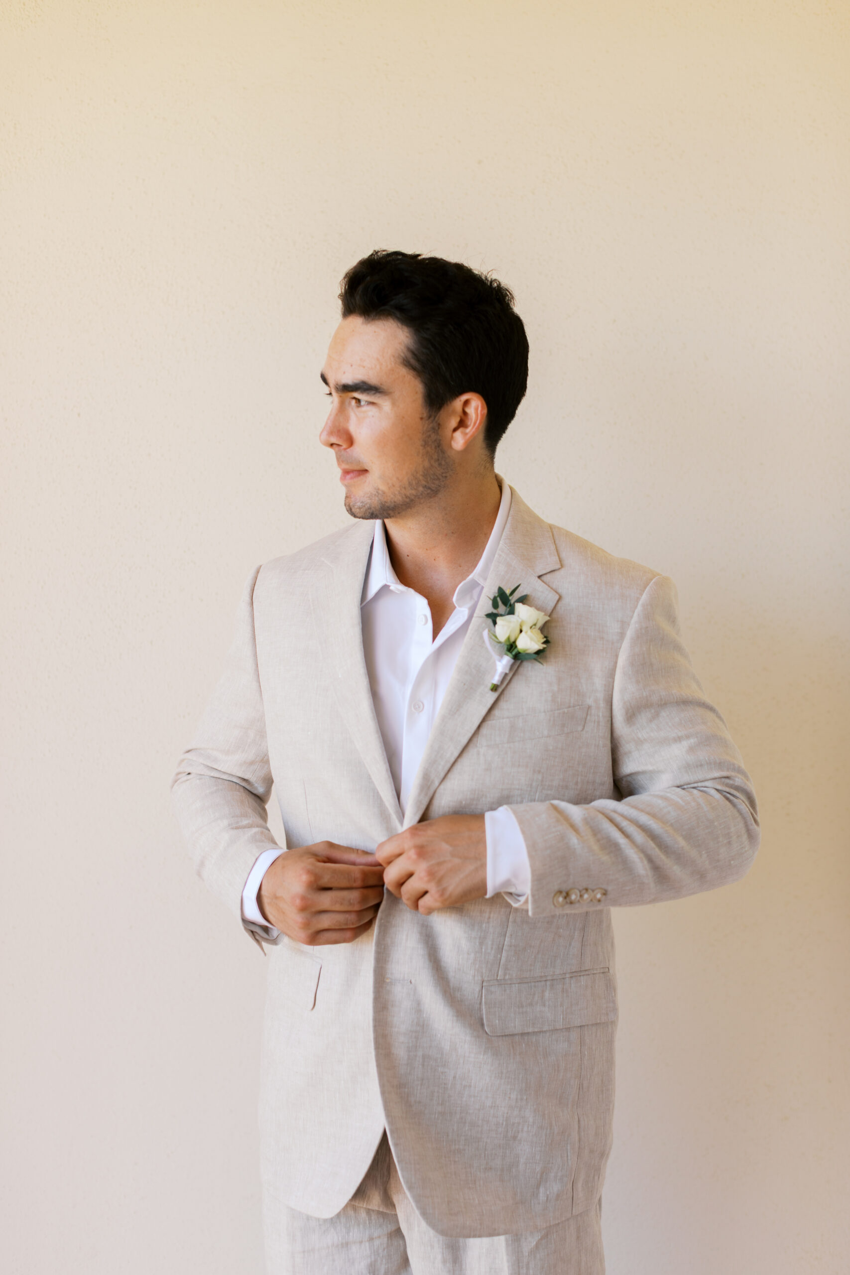 room adjusting cream suit jacket at Hyatt Ziva Cabo San Lucas before beachfront destination wedding