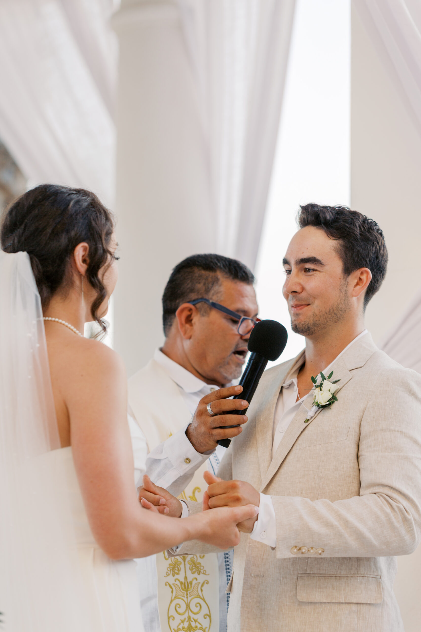Bride and groom exchanging vows during a beachfront wedding ceremony at Hyatt Ziva Los Cabos in Cabo San Lucas.
