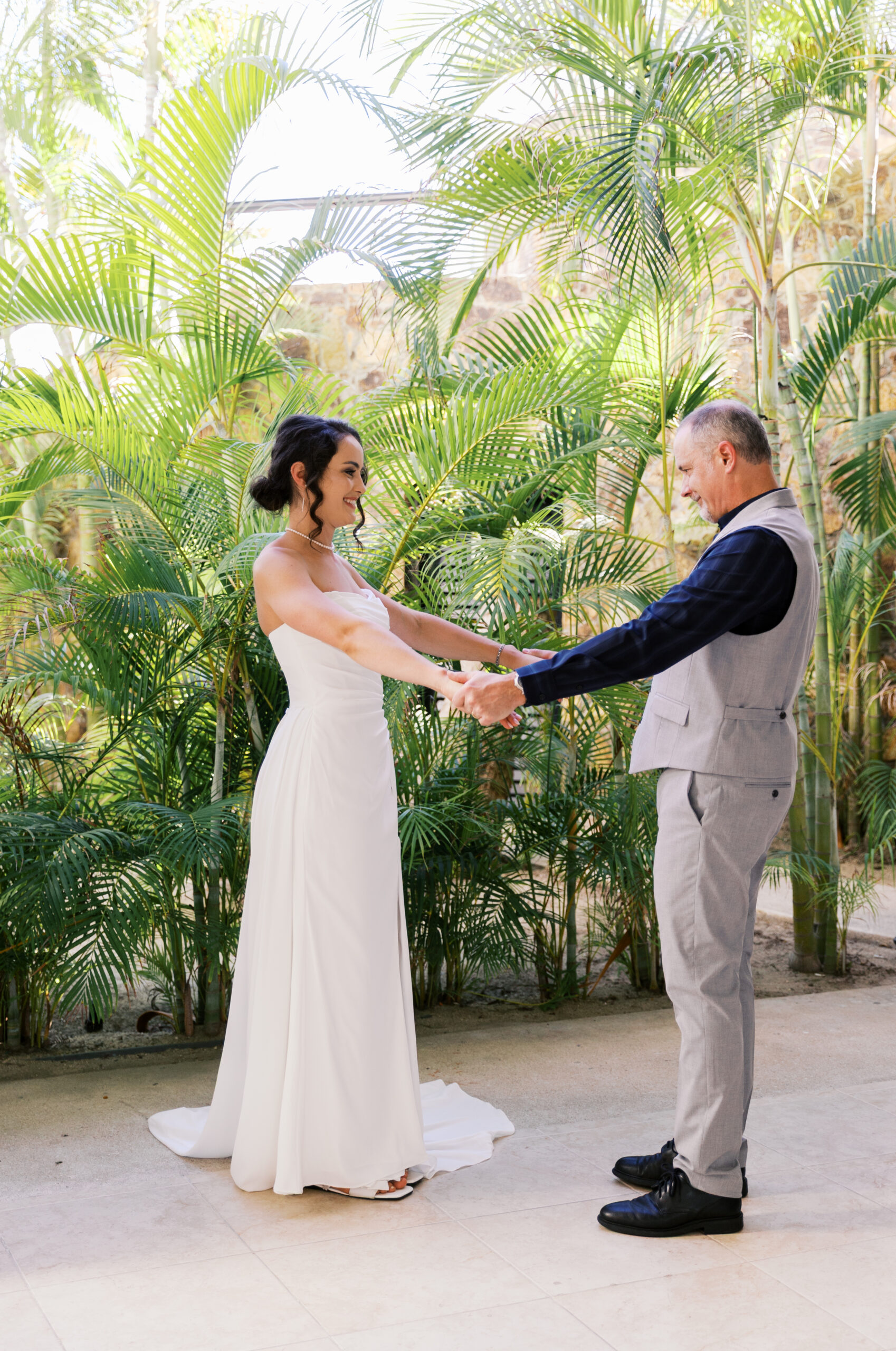 Daddy daughter first look at Hyatt Ziva Los Cabos with bride in strapless gown and father in linen suit surrounded by palm trees