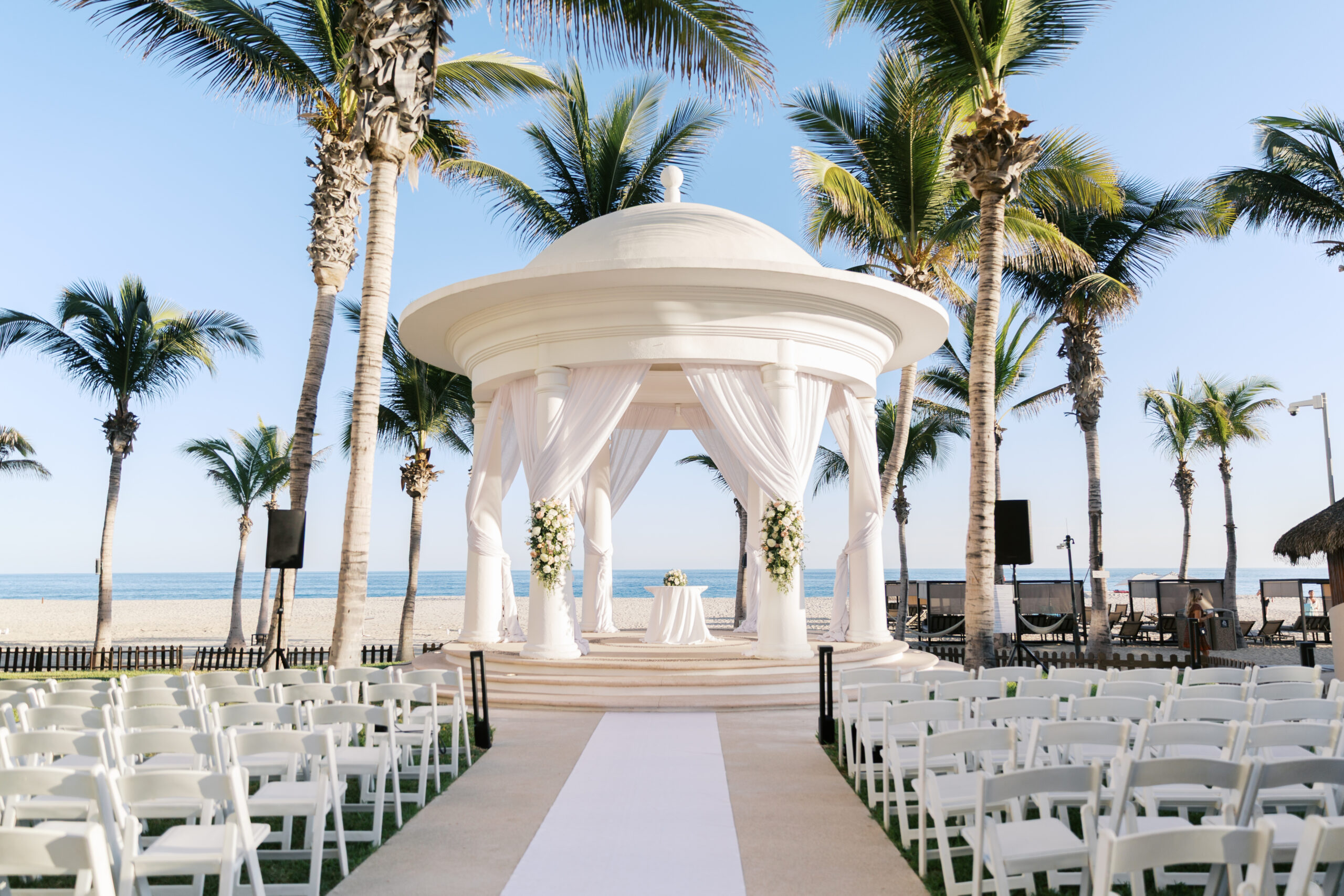 Oceanfront wedding ceremony setup at Hyatt Ziva Los Cabos with white gazebo and palm trees in Cabo San Lucas.