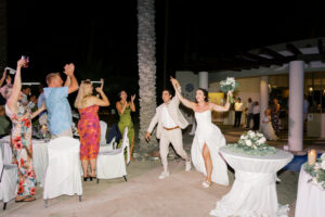 Bride and groom celebrating their grand entrance at Hyatt Ziva Los Cabos wedding reception in Cabo San Lucas.