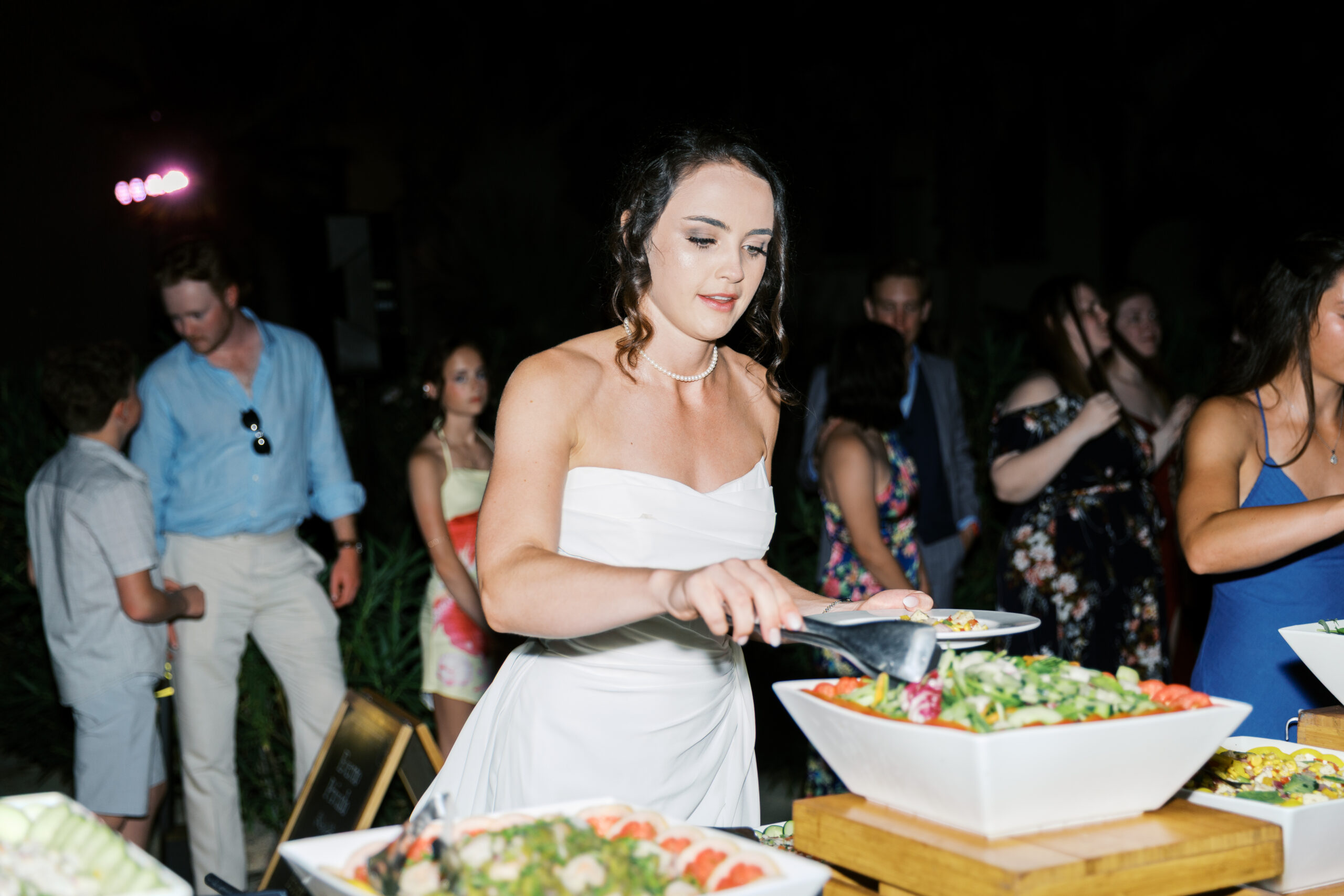 Bride serving herself dinner during outdoor reception at Hyatt Ziva Los Cabos wedding in Cabo San Lucas, Mexico.